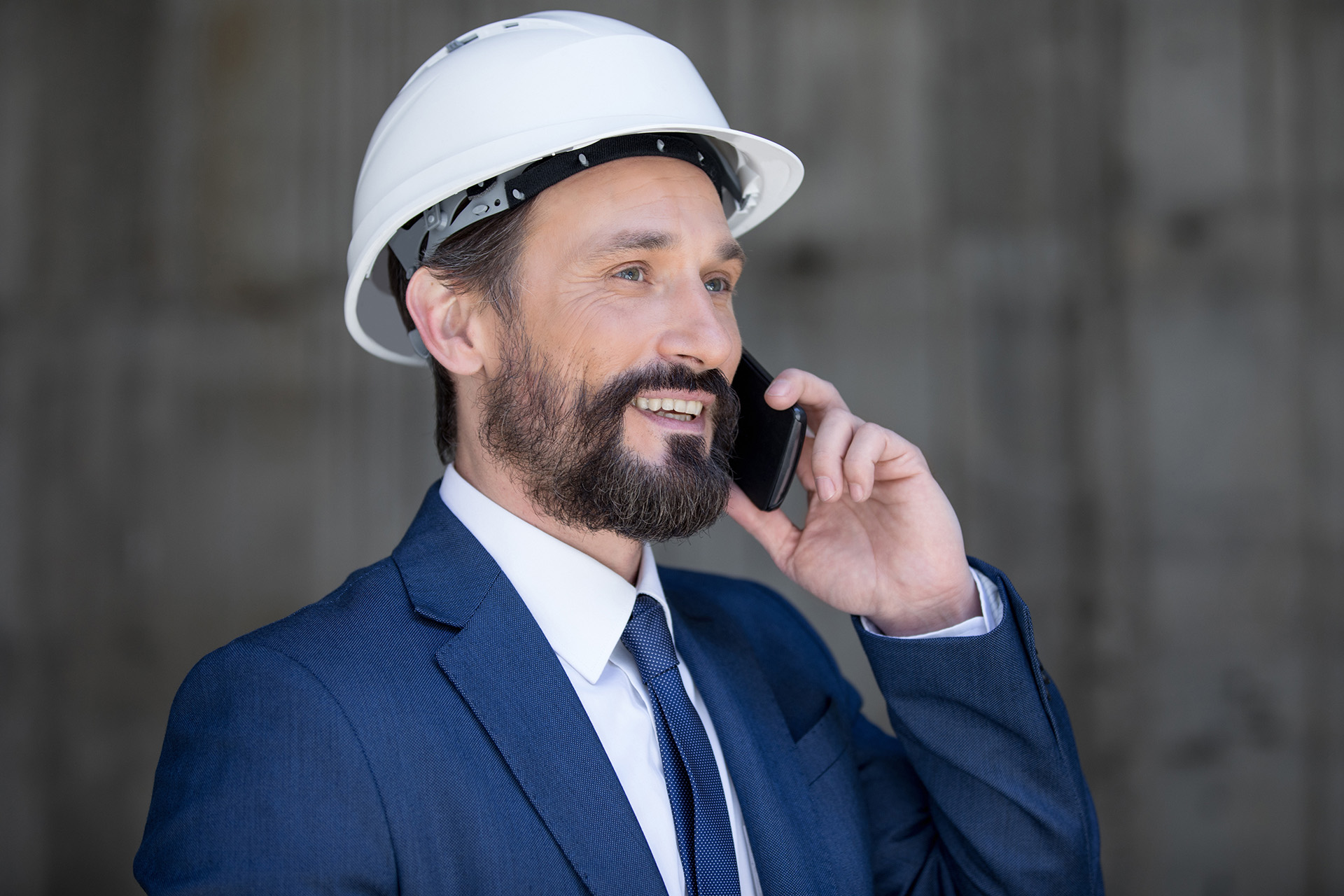 Manager of an industrial company wearing a hard hat contacting MKS on the phone.